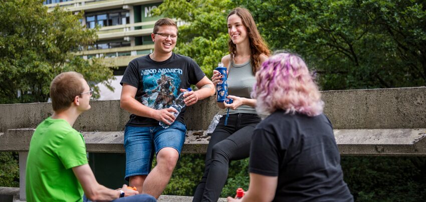 Vier Studierende auf dem Campus.